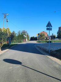 droga na osiedlu w miejscowości Kaleń, po prawej stronie widoczne znaki drogowe